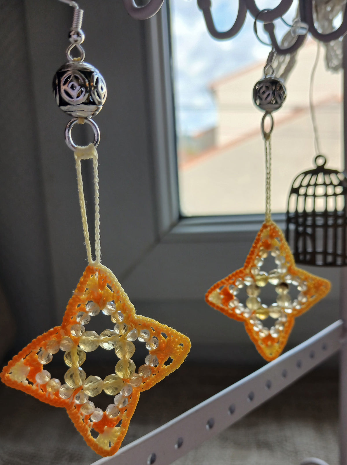 Boucles d'oreilles crochet étoile citrine fluorine – vue de face sur fond de toile