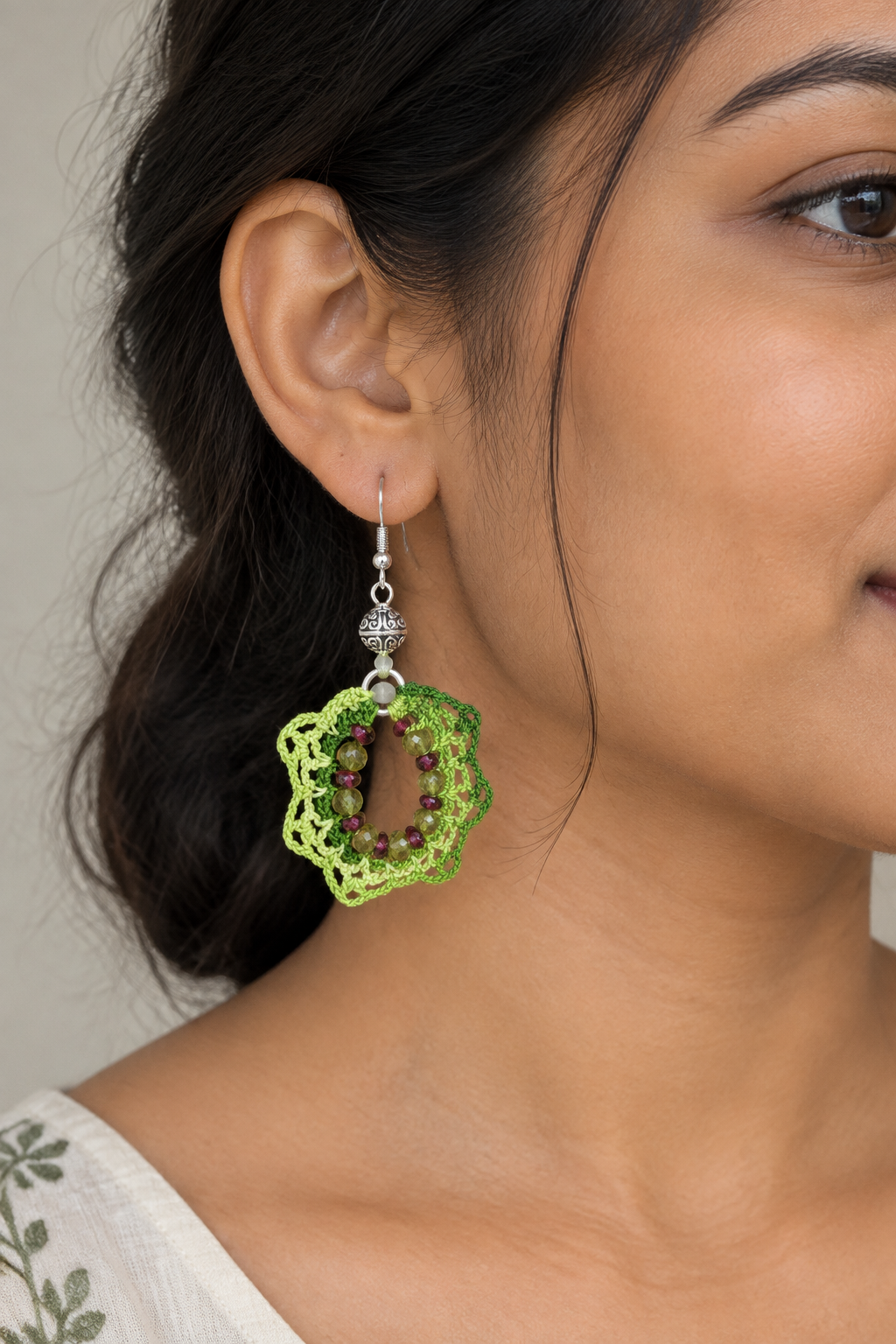 Photo portée illustrative d’une boucle verte sur une jeune femme indienne
